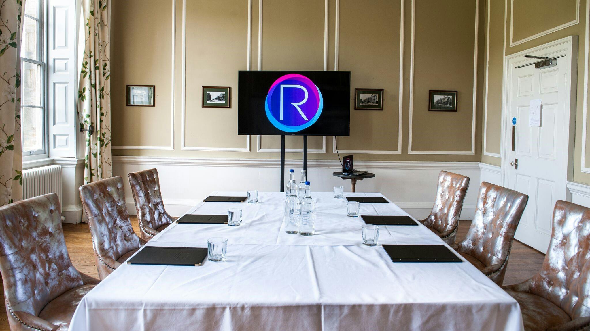 Elegant meeting room with central table, ideal for corporate events and presentations.