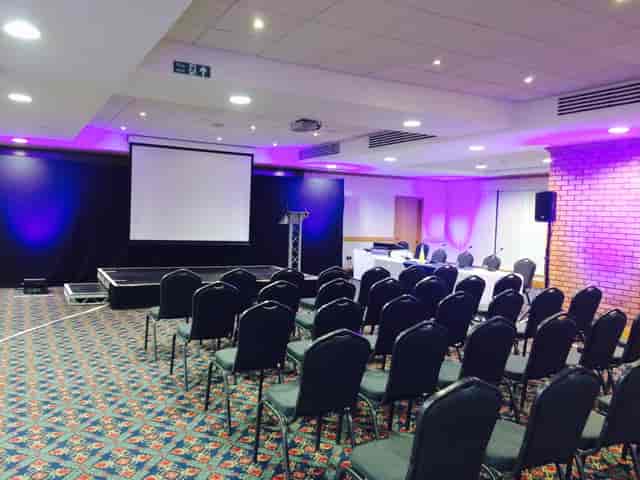 Springfield Lounge event space with stage and projector for conferences and presentations.