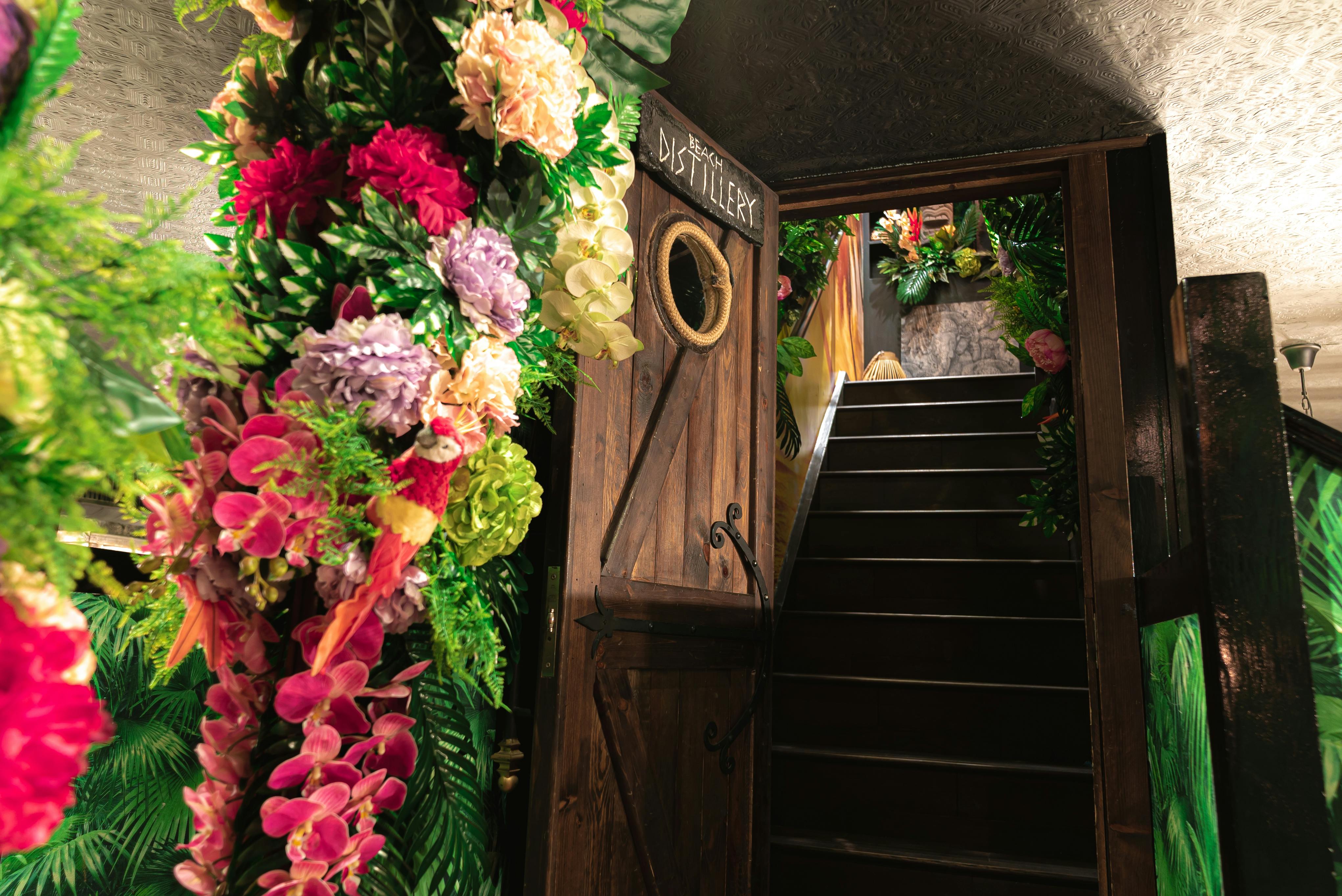 Tropical Escape entrance with vibrant flowers, ideal for whimsical event gatherings.