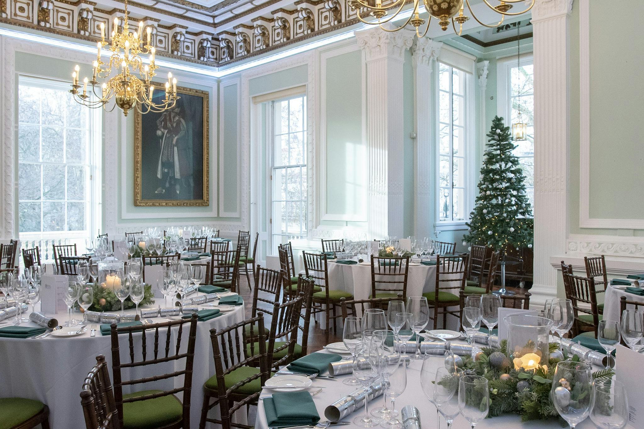 Elegant banquet room at Christmas party in Westminster with fine china and festive decor.