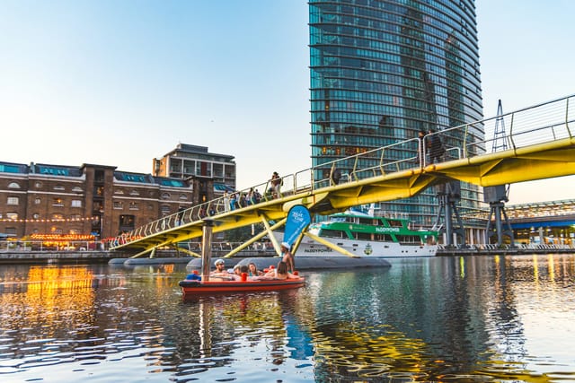 Floating hot tub at waterfront venue with yellow bridge, ideal for outdoor events.