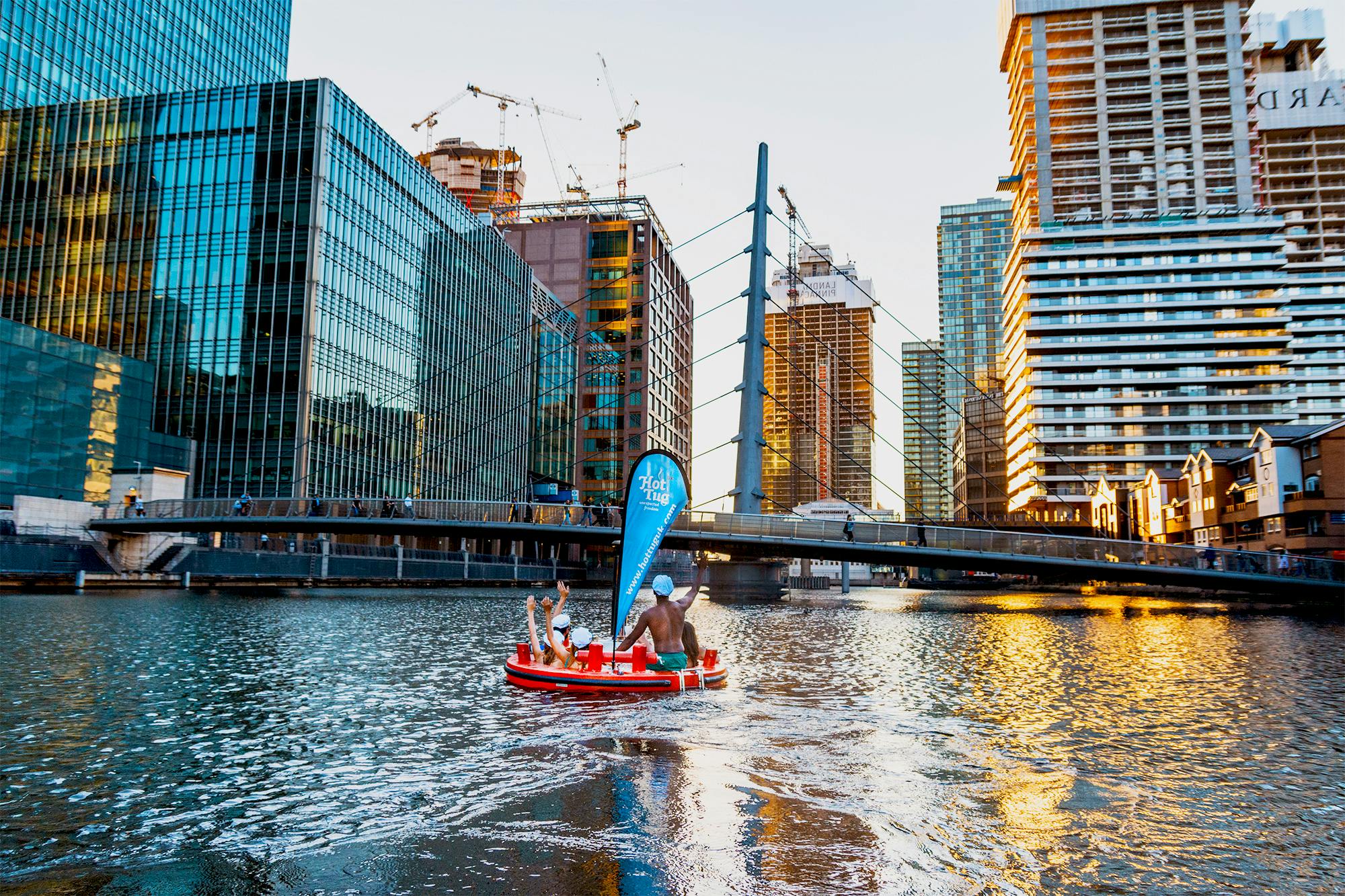 Floating hot tub in urban river setting, perfect for unique team-building events.