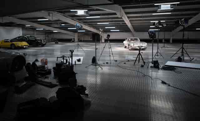 Well-lit automotive studio with sleek cars for product launch or promotional event.