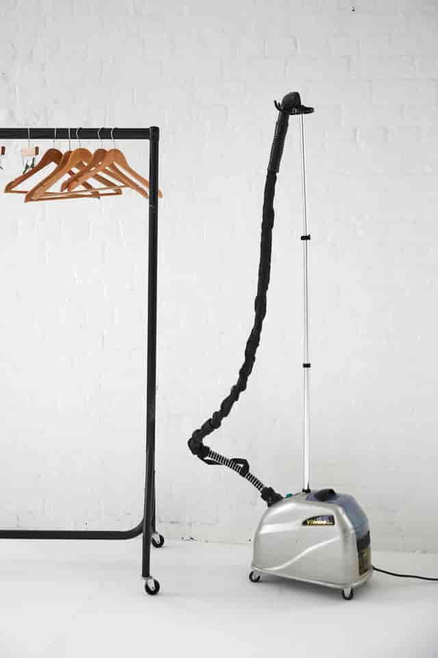 Garment steamer and clothing rack in Tanzaro Studio for professional event preparation.