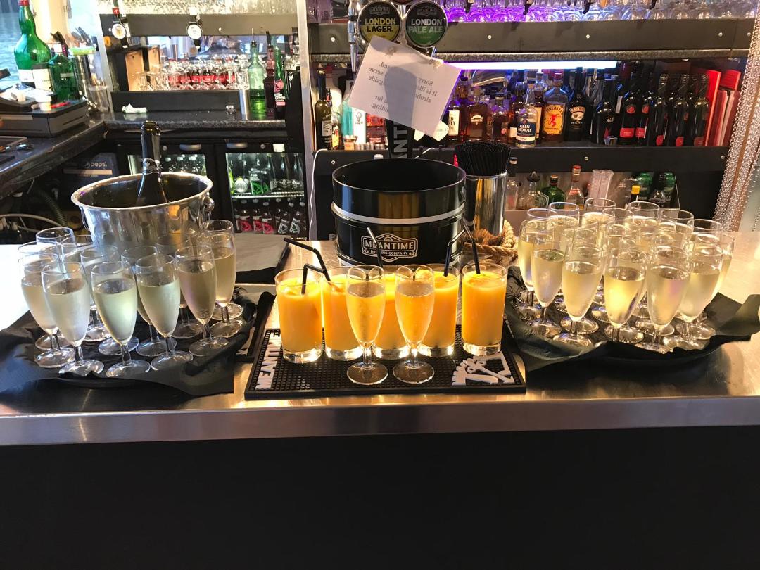 Elegant beverage station with champagne and mimosas for a celebratory event. - Banner