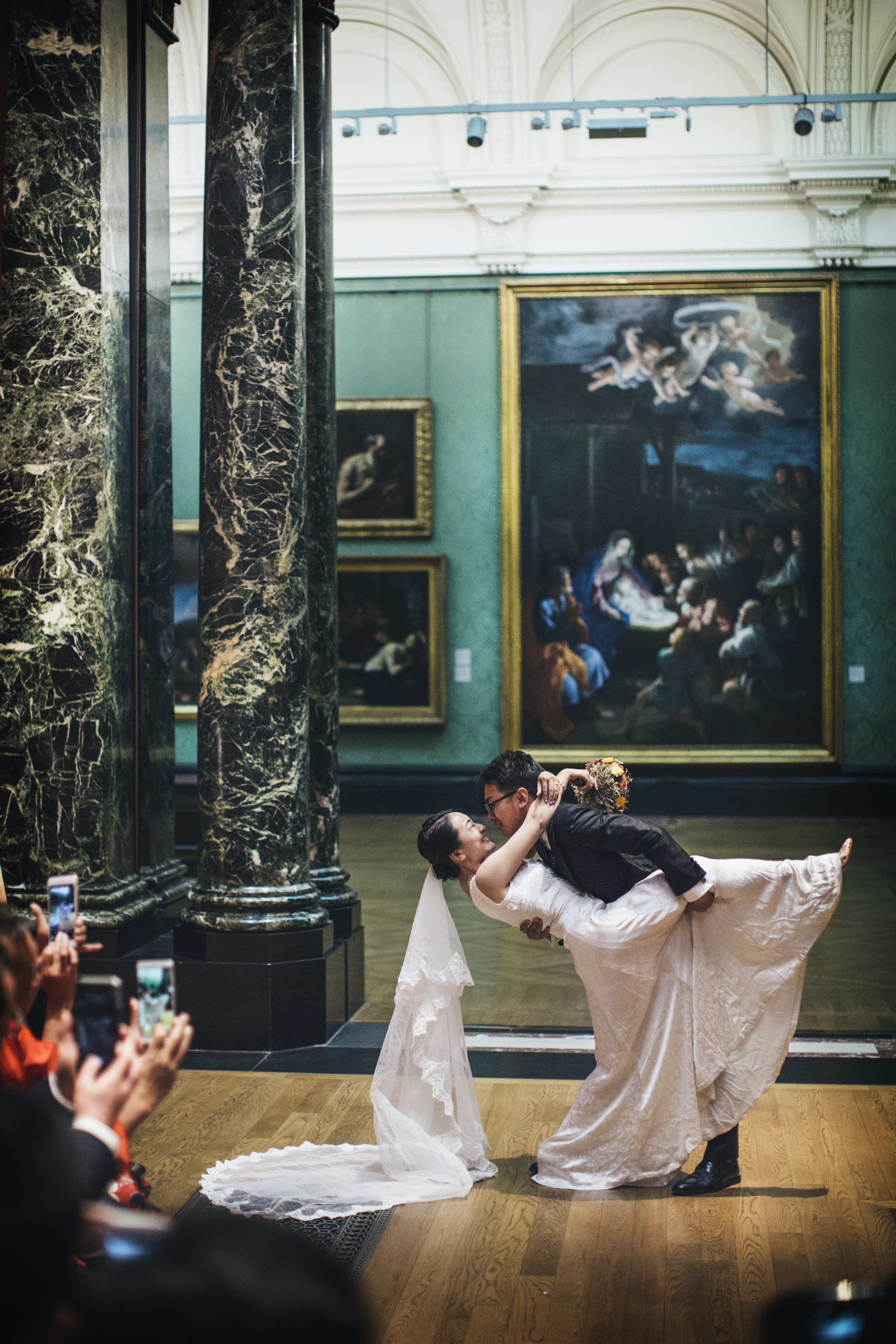 Couple celebrating wedding in elegant National Gallery with stunning artwork backdrop.