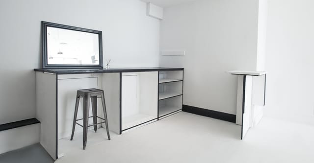 Minimalist event space with modern bar, ideal for networking and cocktail receptions.