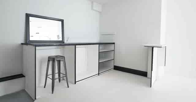 Minimalist event space with sleek bar, ideal for networking and cocktail receptions.