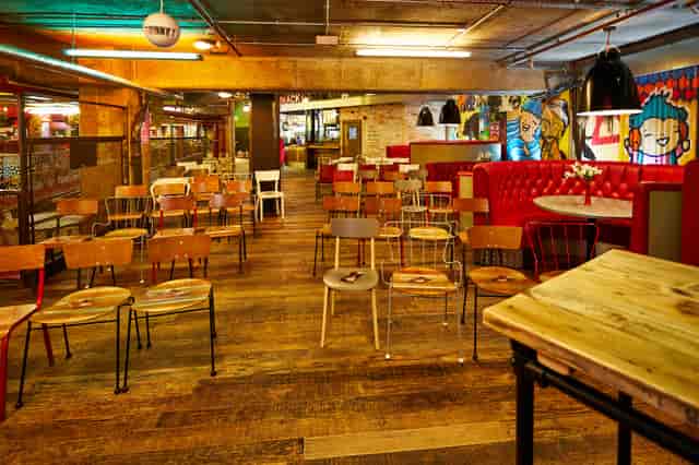 Versatile urban courtyard with wooden floors for casual meetings and creative workshops.