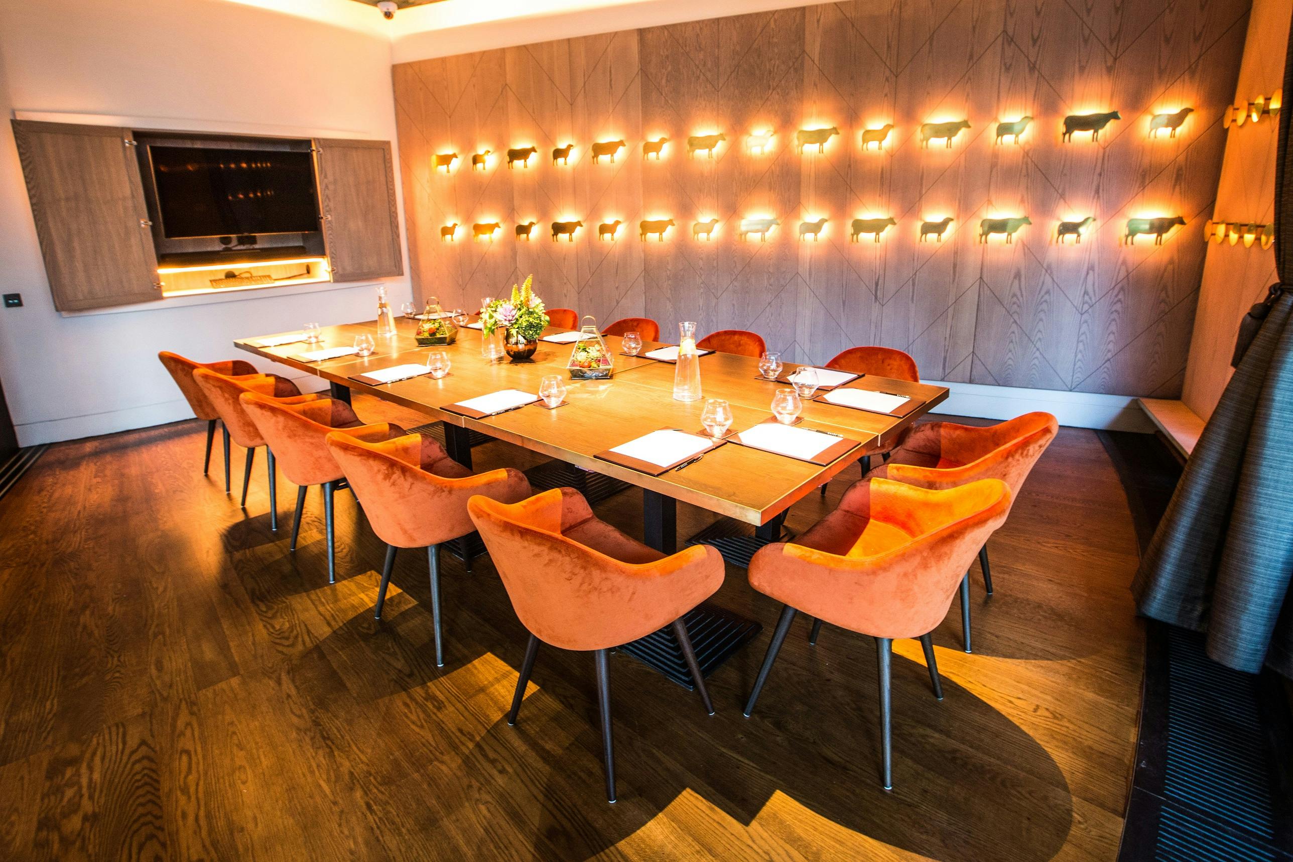 Private dining room with orange chairs, ideal for intimate meetings and events.