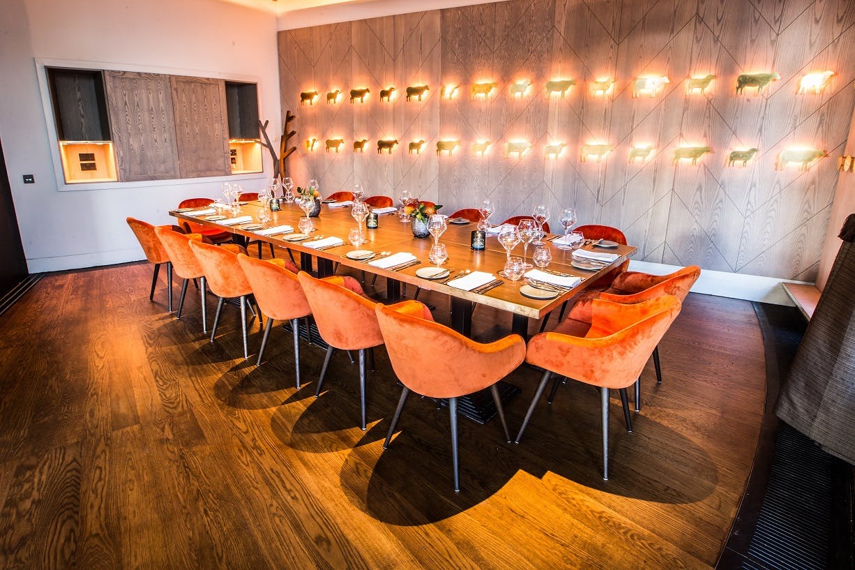 Private dining room with wooden table and orange chairs for intimate events.