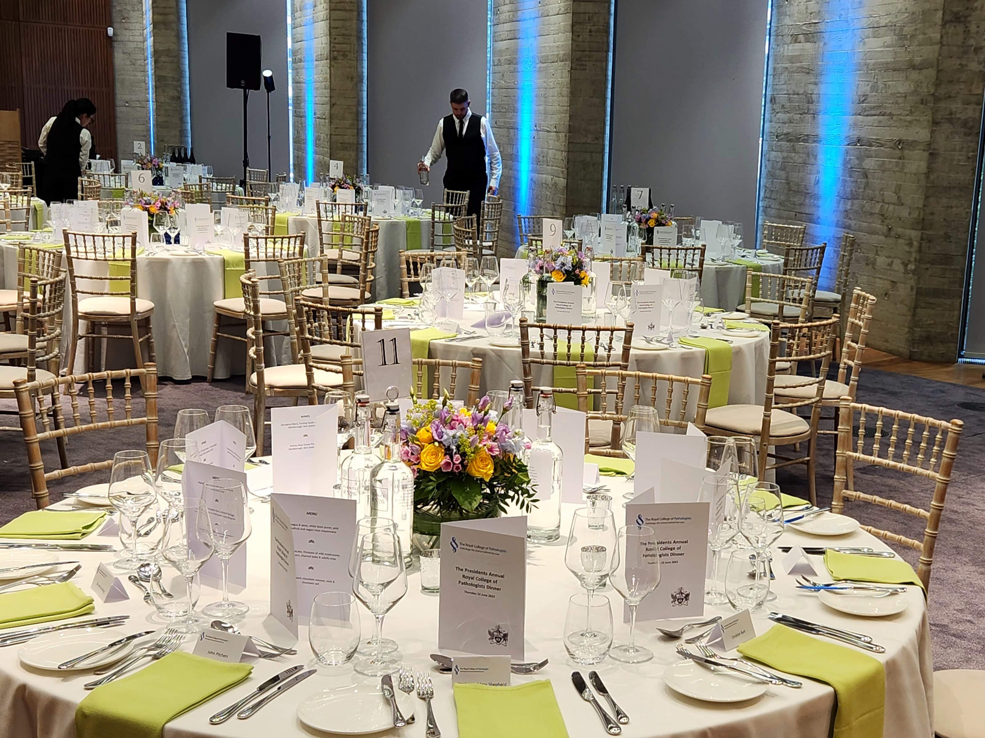 Elegant event space with white linens and floral centerpieces for formal gatherings. - Banner