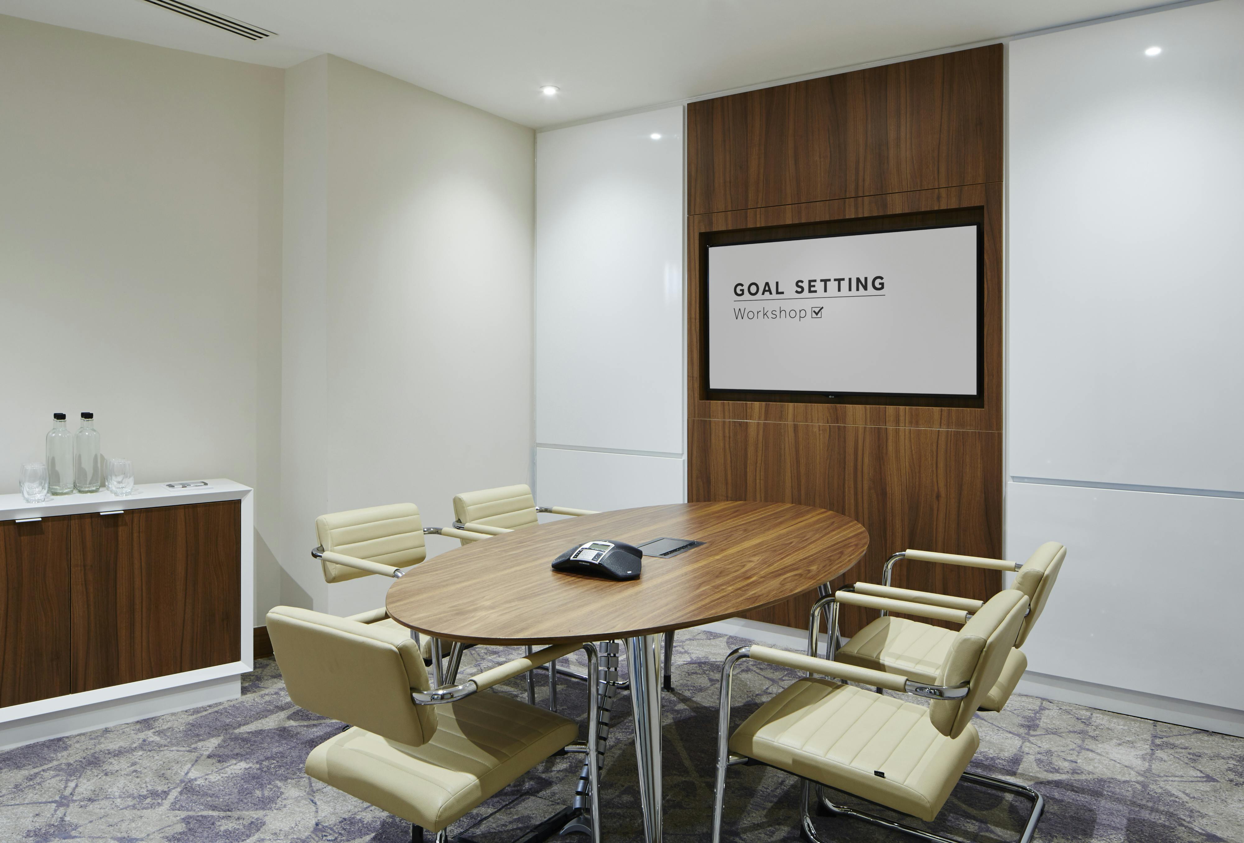 Modern meeting room at London Heathrow Marriott with sleek wooden table for strategic planning.