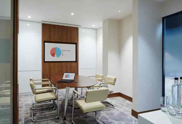 Modern meeting room with round table at London Heathrow Marriott for strategic planning.