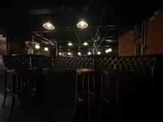 Intimate Whiskey Jar Basement venue with sleek leather seating for networking events.