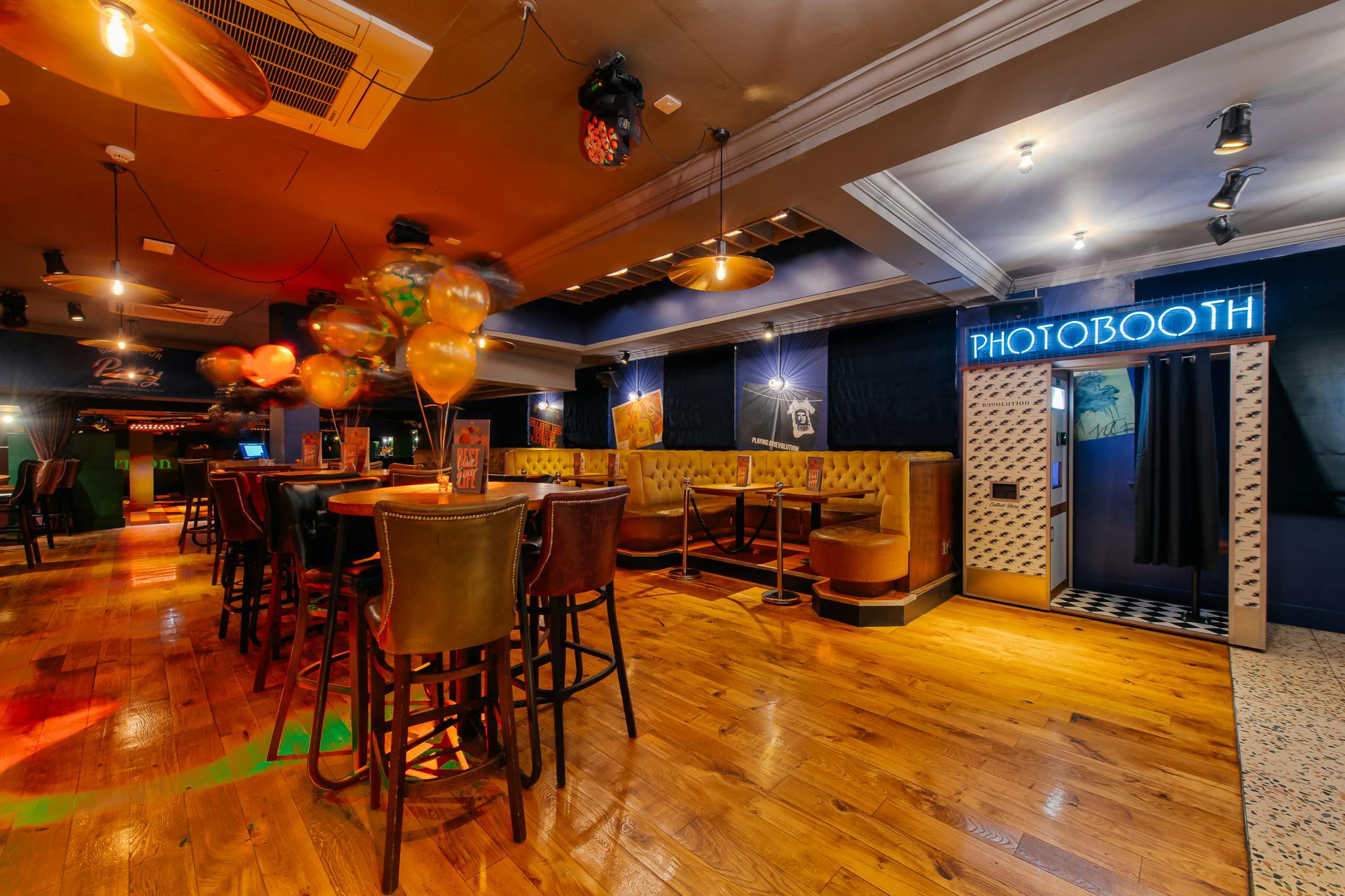 Vibrant event space with stylish bar and photobooth for social gatherings or corporate events.