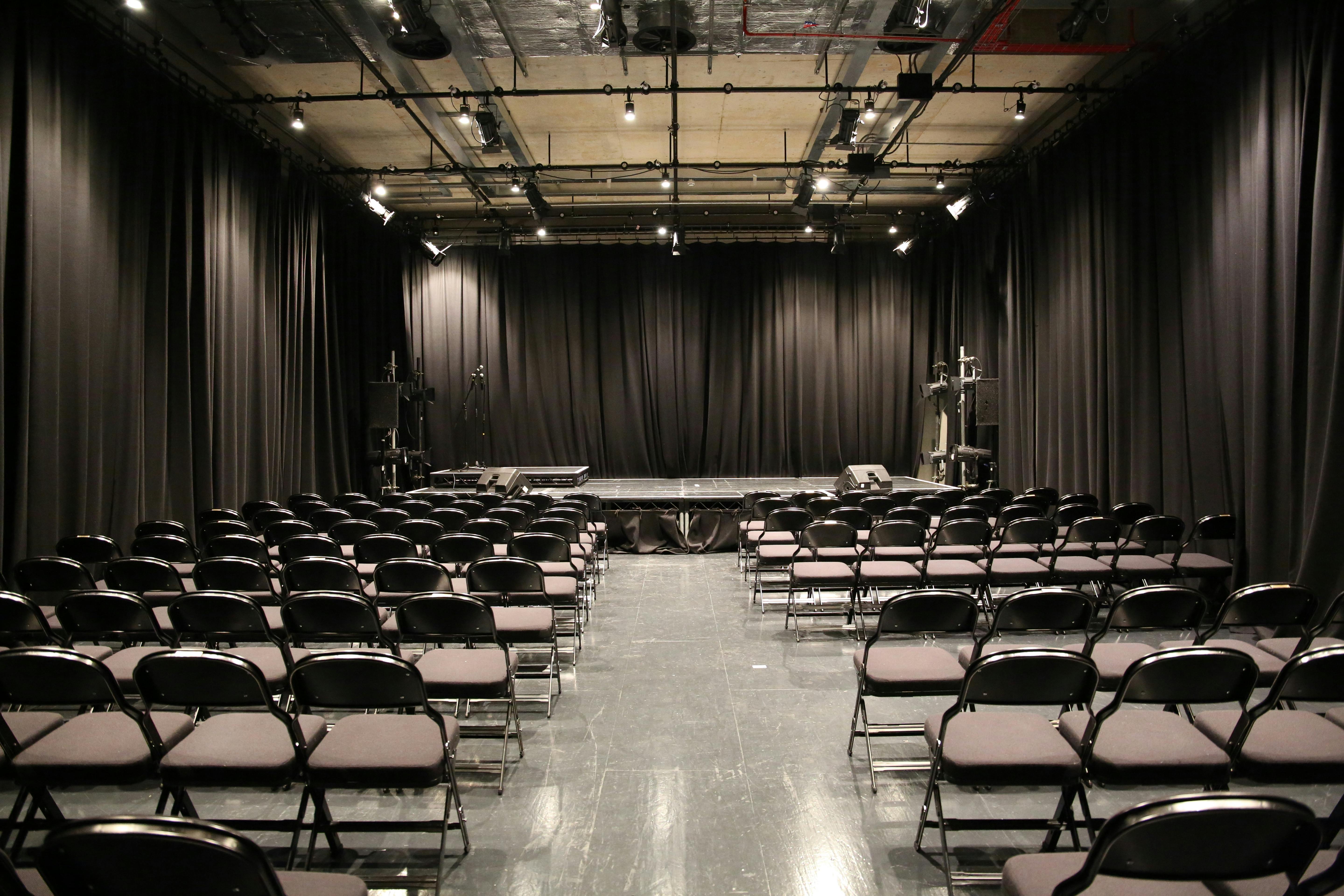 Versatile event space with black curtains for presentations and performances in Streatham.