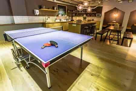 Versatile modern cafe venue with ping-pong table for team-building activities.