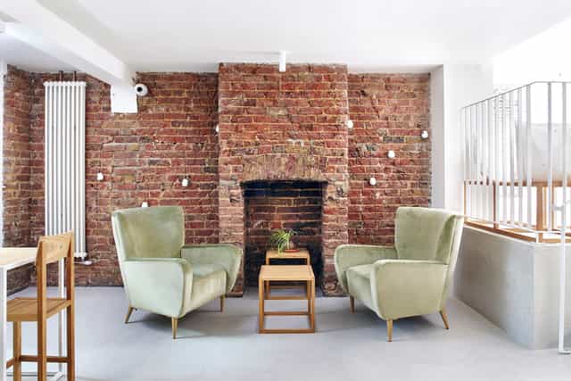 Stylish meeting space with plush armchairs at Unico Notting Hill for casual gatherings.