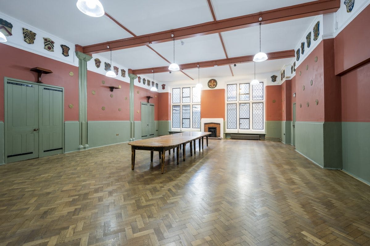 Spacious Toynbee Hall lecture room with wooden table for meetings and workshops.