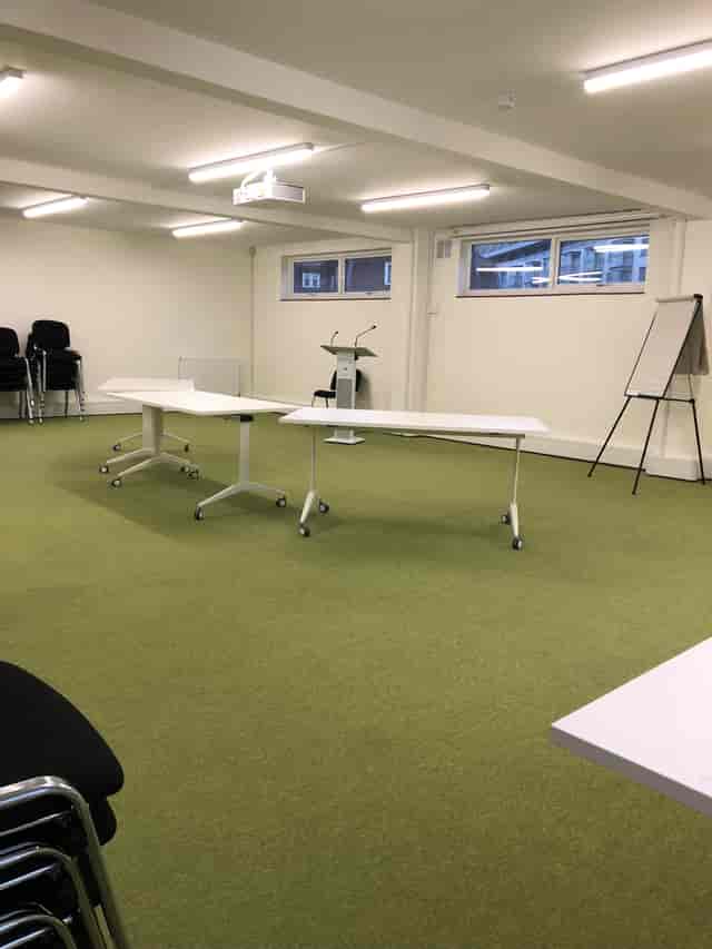 Flexible training room with mobile tables, ideal for workshops and brainstorming sessions.