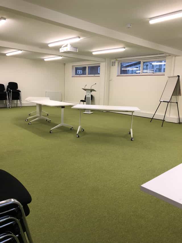 Flexible training room with mobile tables, ideal for workshops and brainstorming sessions.