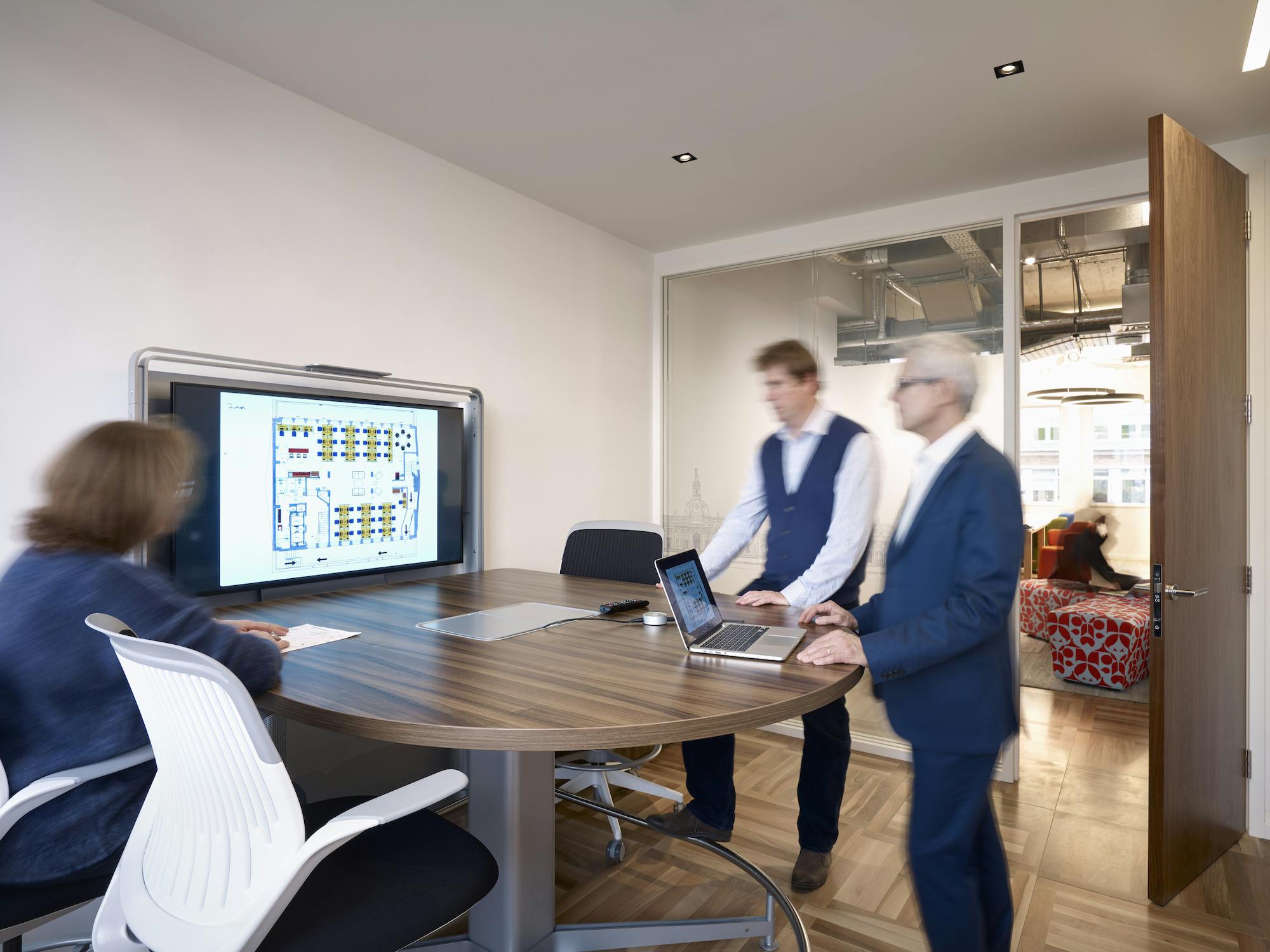 Modern meeting room with large digital display for presentations and brainstorming.