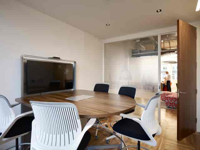 Modern meeting room with round wooden table for collaborative events at Us&Co Monument.