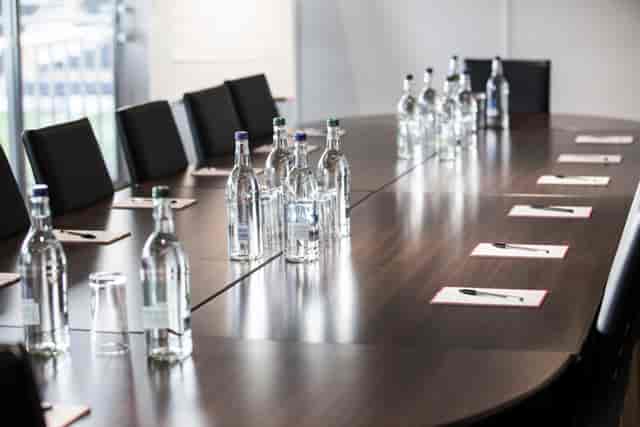 Conference room at Fulham FC Superbox with sleek table, notepads for meetings.