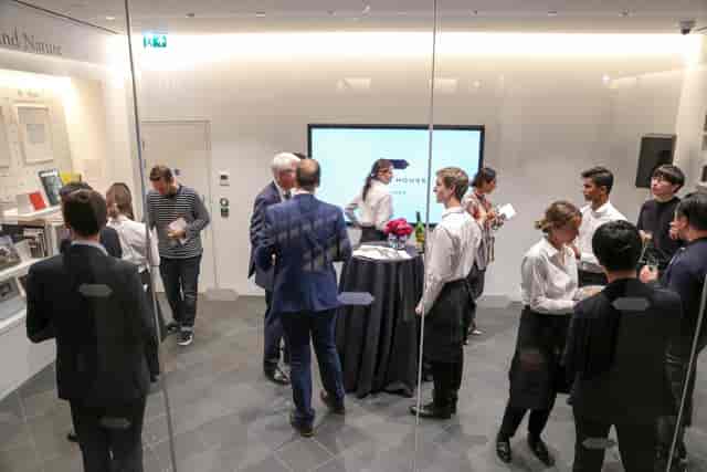 Networking event in Japan House library with sleek design and engaged attendees.