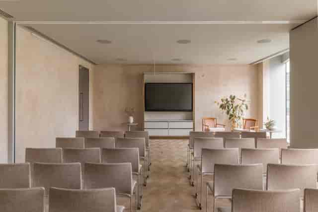 Meeting space with chairs and large screen at The Stratford, ideal for workshops and presentations.