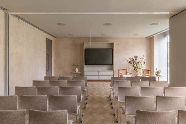 Meeting space with chairs and large screen at The Stratford, ideal for workshops and presentations.