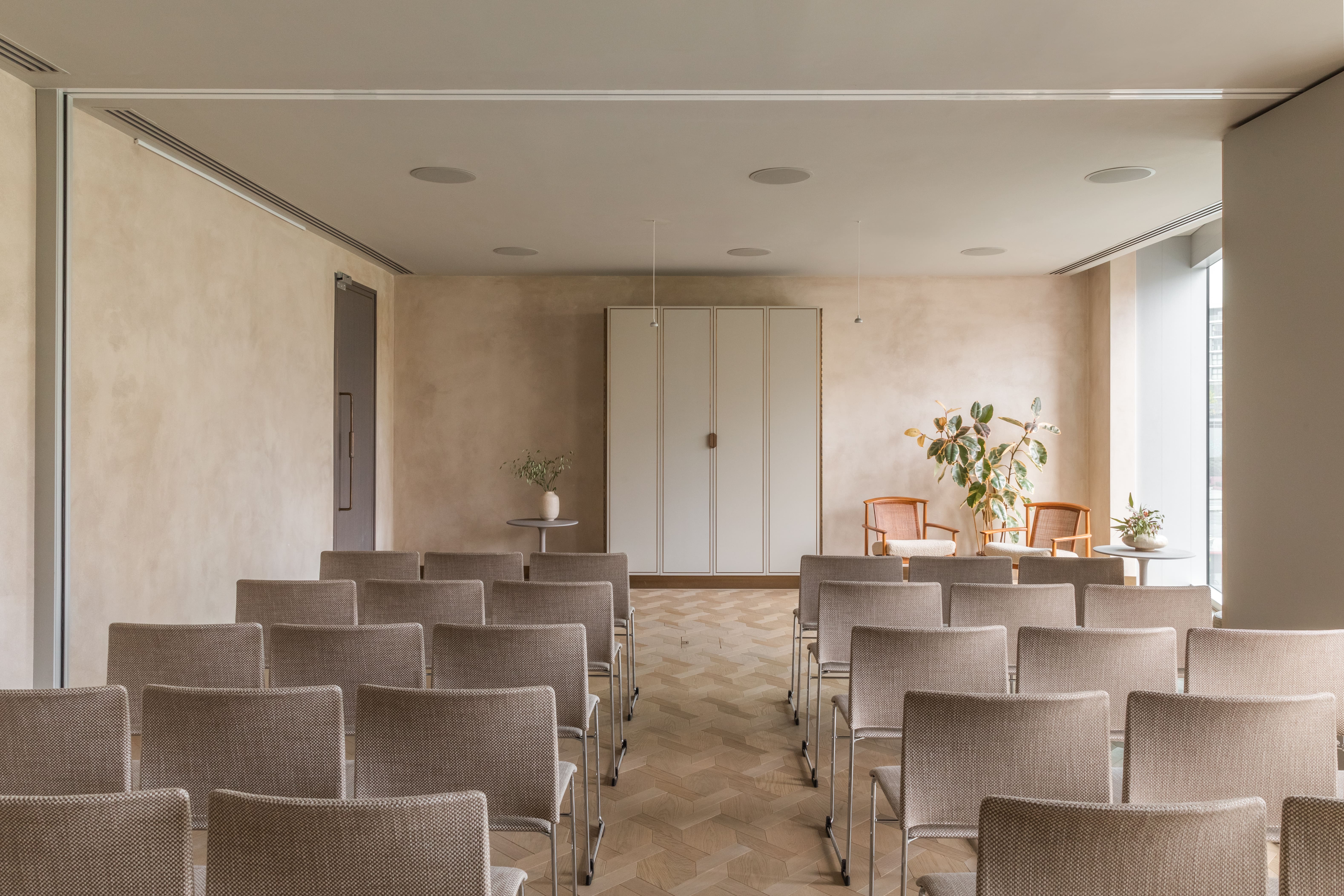 Minimalist meeting space with natural light for intimate gatherings and workshops. - Banner