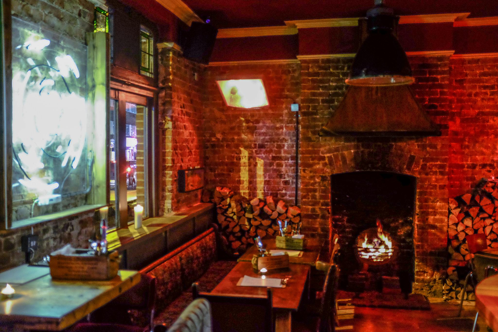 Cozy semi-private pub area with exposed brick, ideal for networking events and gatherings.