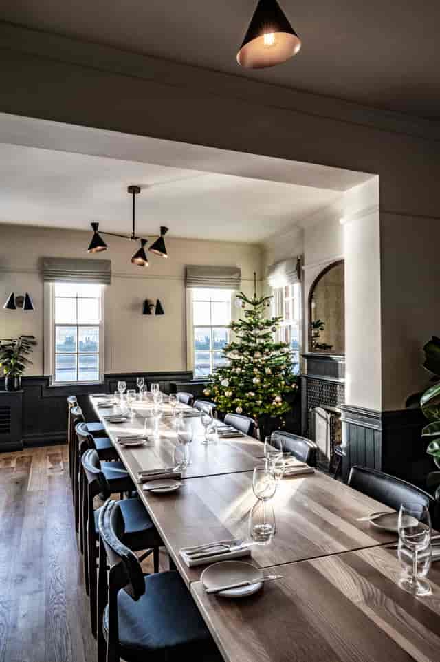 "Elegant meeting space with long table and Christmas tree at Bread Street Kitchen, Limehouse."