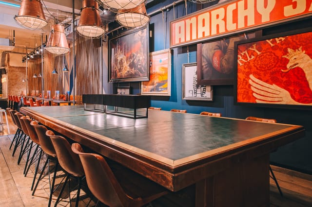 Stylish meeting space in Glasgow library with inviting table and modern chairs.