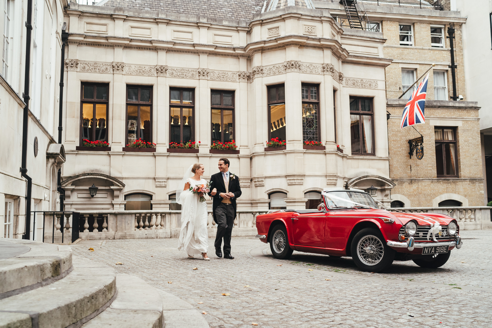 Couple in elegant attire at Weddings in Stationers' Hall, vintage car backdrop. - Banner