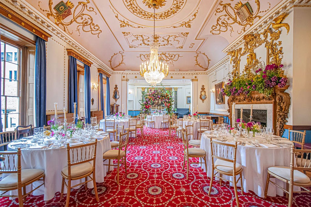 Elegant wedding venue with ornate ceiling and floral arrangements at Stationers' Hall.