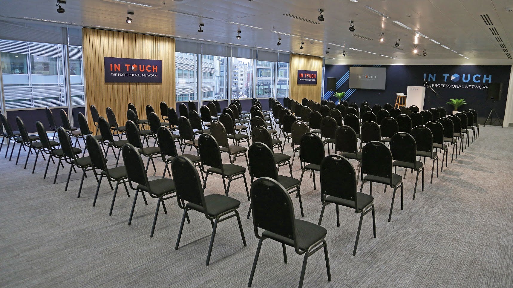 Spinningfields Suite in Manchester, modern seminar space with black chairs and natural light.