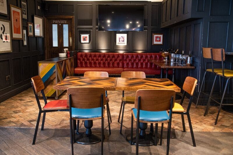 Cozy meeting space with red banquette, ideal for creative gatherings and brainstorming.