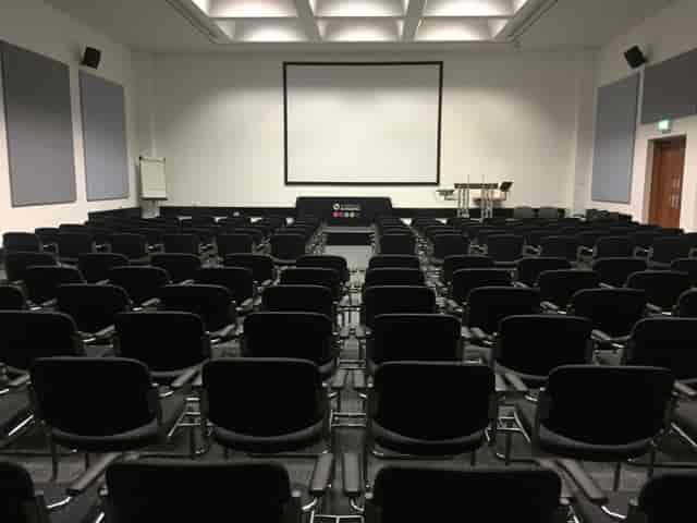 Conference room with black chairs and large screen for presentations and meetings.