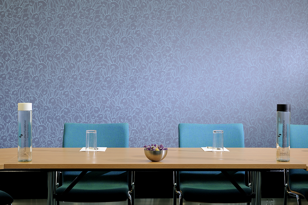 Modern meeting room with floral wall, ideal for discussions and brainstorming sessions.