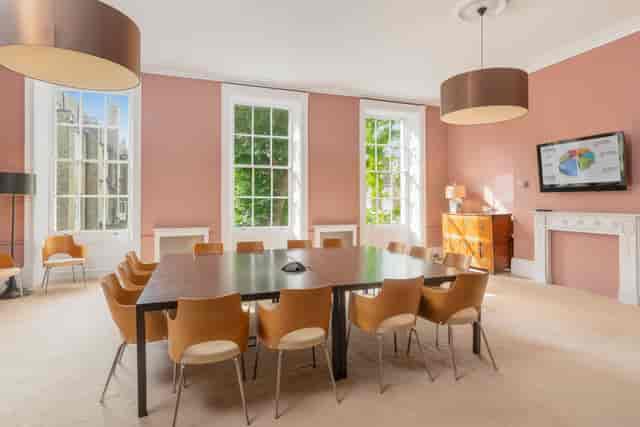 Private Gardens View Room with central table, ideal for meetings and brainstorming sessions.