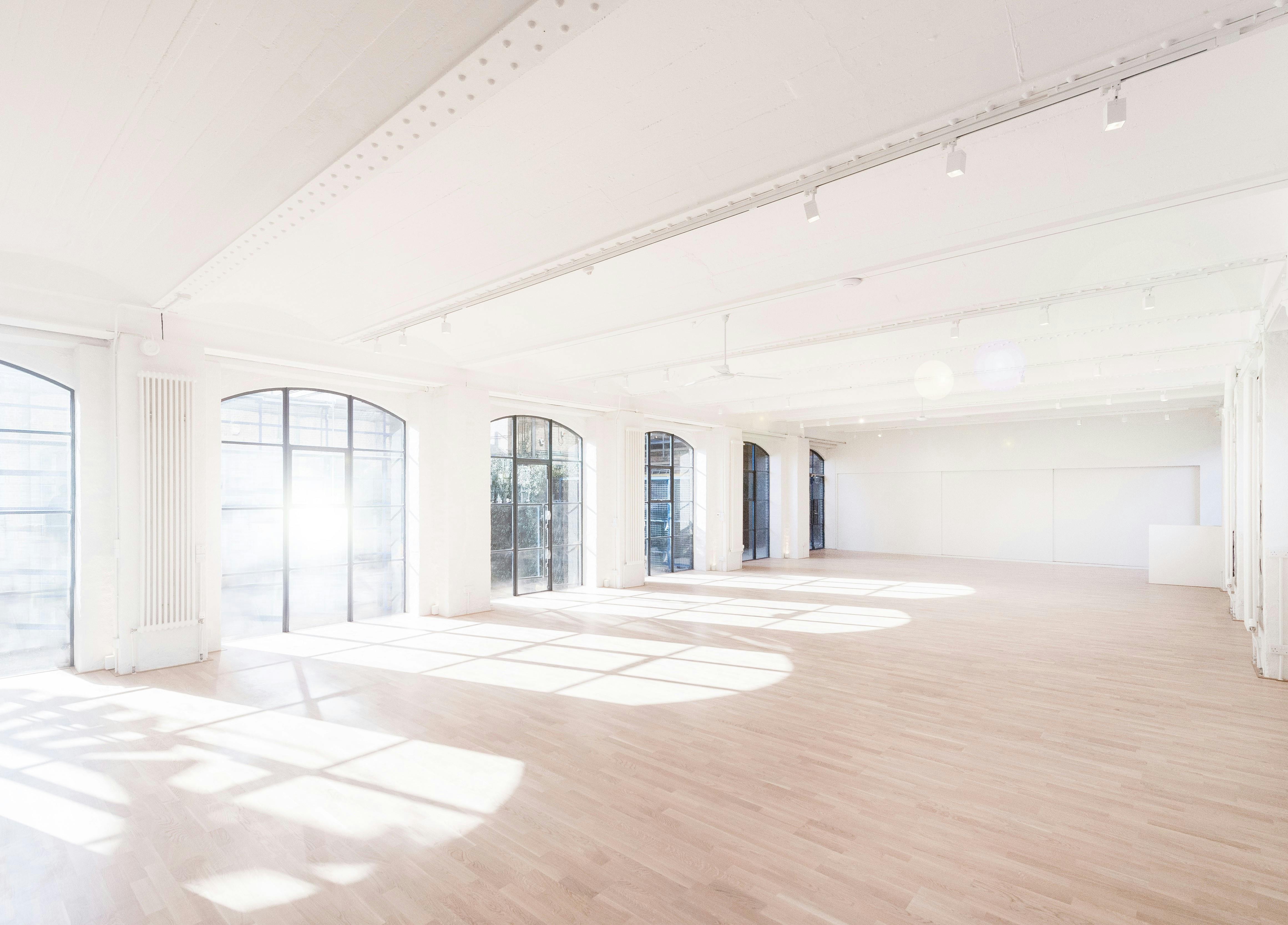 Spacious workshop venue with large windows, ideal for corporate events and gatherings.