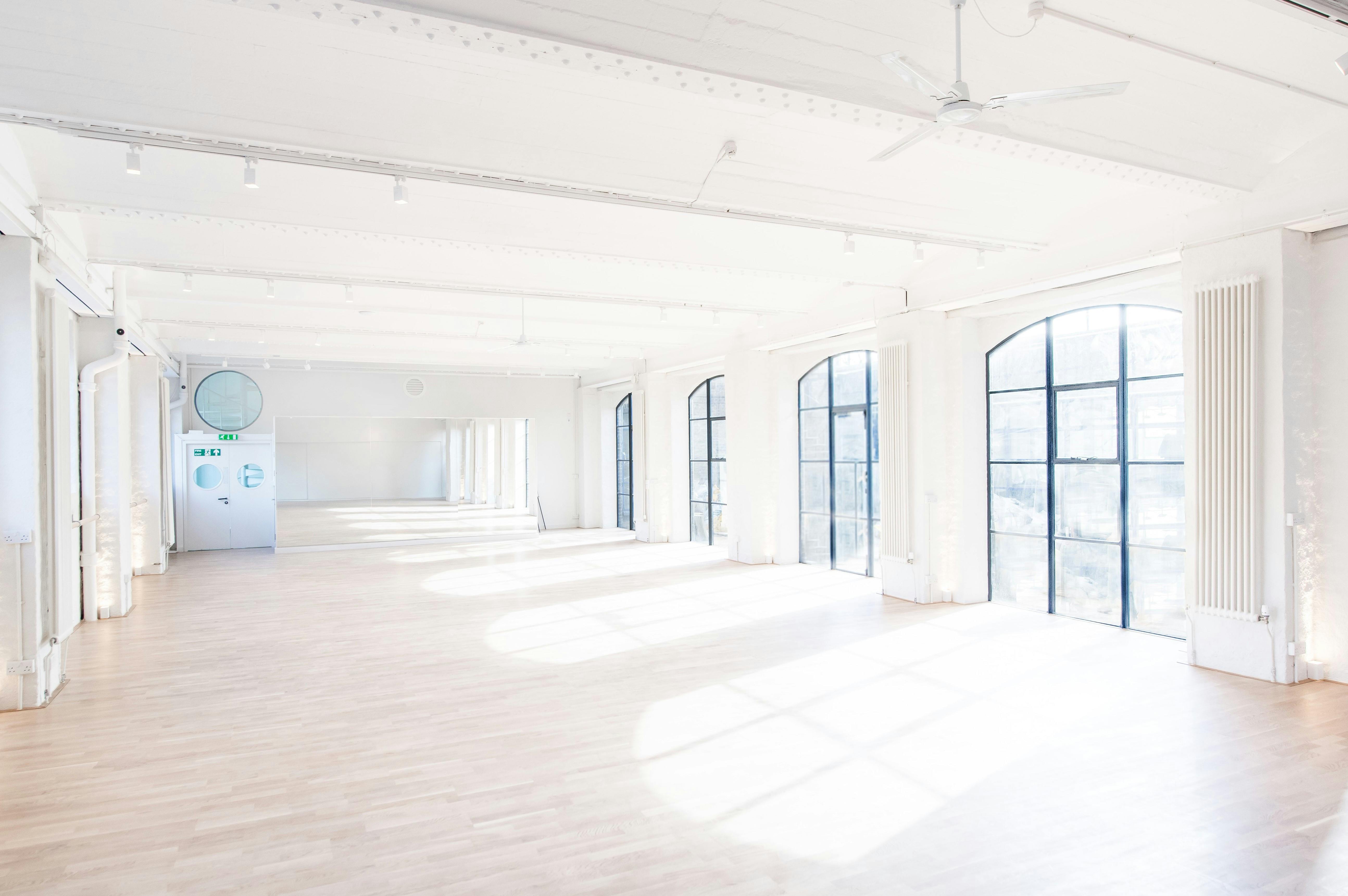 Bright workshop space with large windows, ideal for corporate events and workshops.