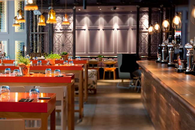 Modern restaurant venue with vibrant red tables, perfect for events and gatherings. - Banner
