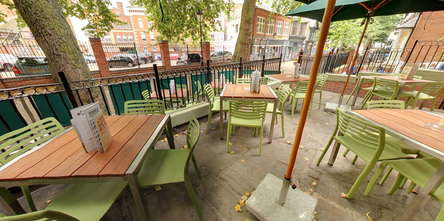 Outdoor seating area with green chairs at Revolution Leicester for casual meetings and events.