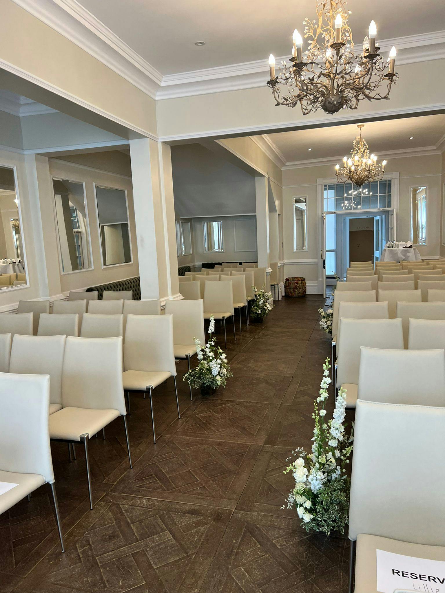 Elegant event space with white chairs, perfect for weddings and ceremonies.