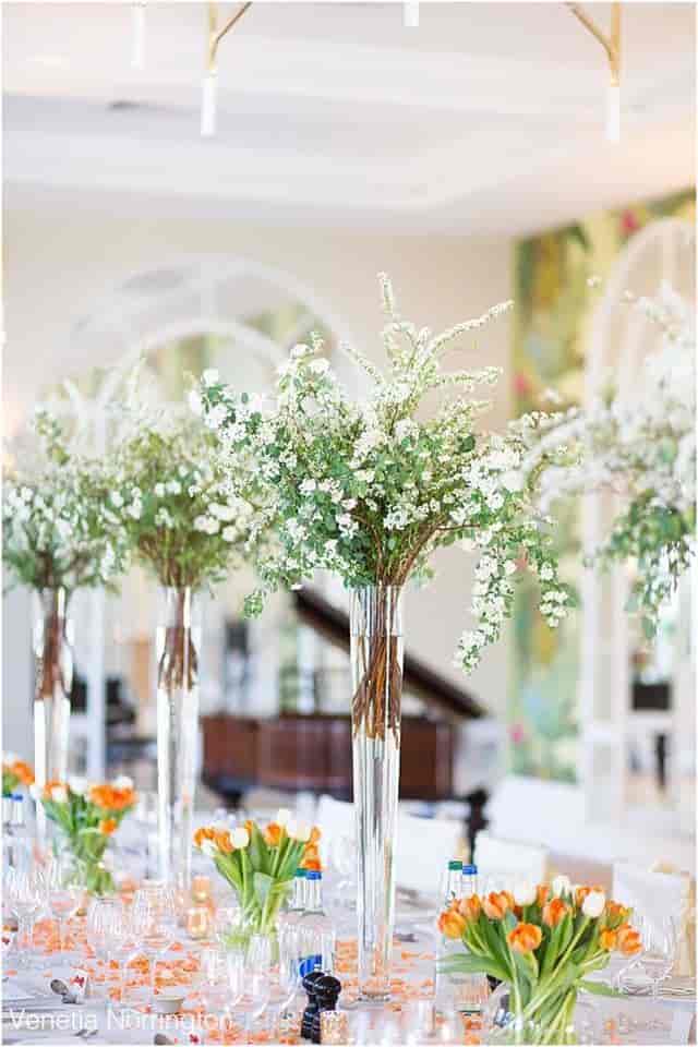 Elegant floral arrangements in tall vases for weddings and corporate events.