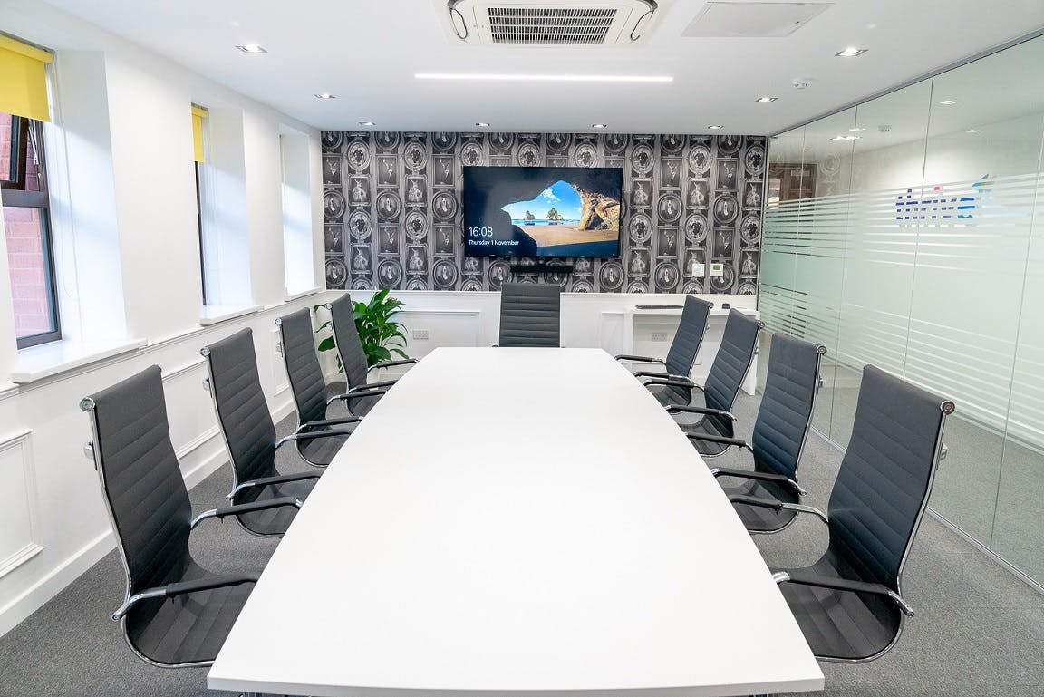 Modern conference room in Foundry House, Widnes with ergonomic chairs and large screen.